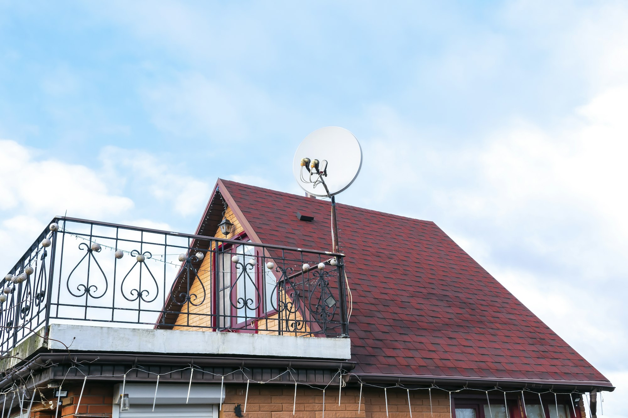 private house shingle tile rooftop,satellite dish antennas.Real estate property.Wireless television